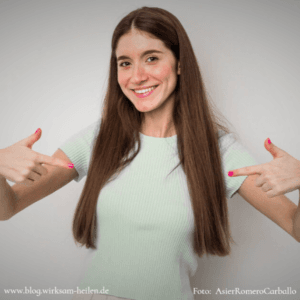 Selbstbewusstes Mädchen zeigt lächelnd mit den Fingern auf sich