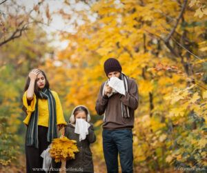 Familie läuft schneuzend erkältet im Wald.