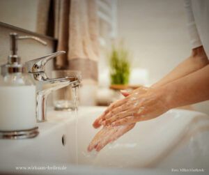Hände werden mit Seife im Waschbecken gewaschen.