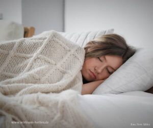 Junge Frau schläft mit Wolldecke.