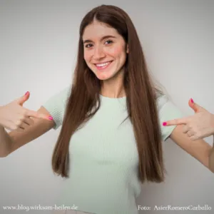 Selbstbewusstes Mädchen zeigt lächelnd mit den Fingern auf sich