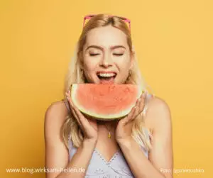 Blonde Frau beisst in Wassermelone