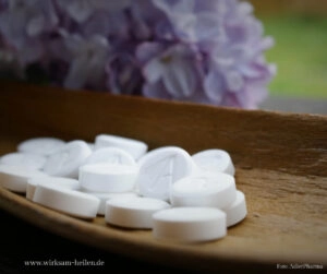 Schüßler Salze Tabletten liegen präsentiert auf einem Tisch.